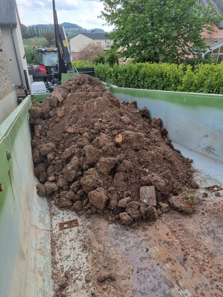 Terre évacuée par un camion benne après des travaux d'excavation.