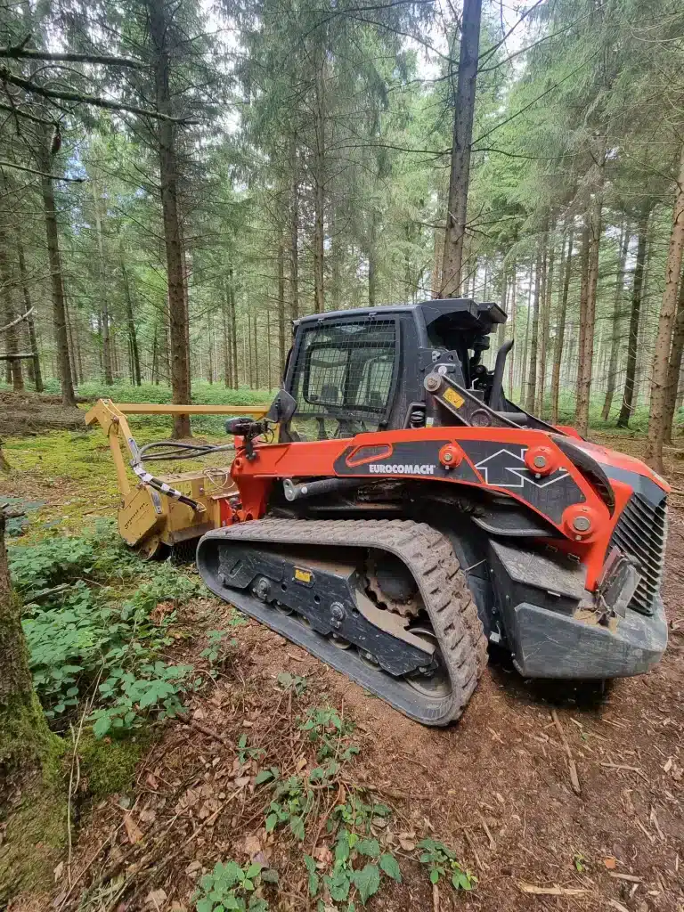 Utilisation d'une chargeuse sur chenilles en forêt.